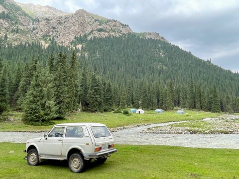 A rugged Lada Niva parked in a Red Water Valley, surrounded by breathtaking natural scenery, Kyrgyzstan, 28.07.2025.