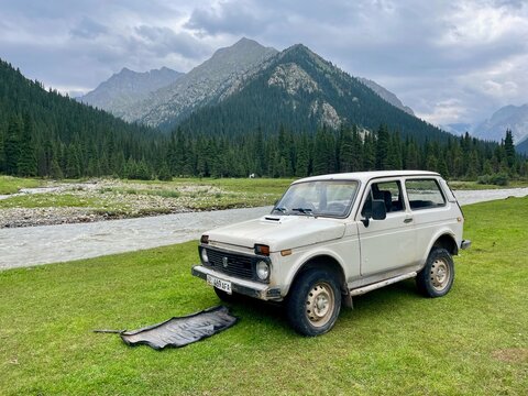 A rugged Lada Niva parked in a Red Water Valley, surrounded by breathtaking natural scenery, Kyrgyzstan, 28.07.2025.