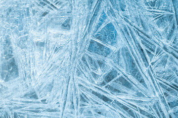A detailed macro texture of sharp ice crystals forming natural geometric patterns. Perfect for backgrounds, overlays, and winter-themed visual design.
