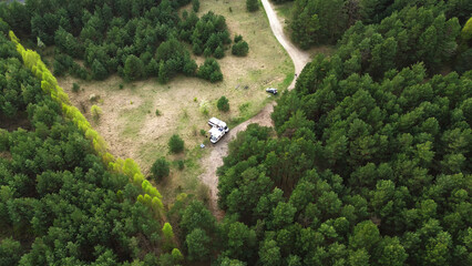 Camper van at dirt road in forest
