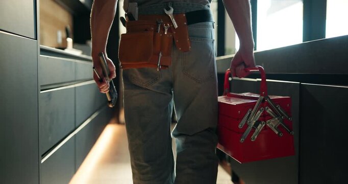 Tool box, plumber and walk with man in kitchen for home improvement, pipe maintenance and leak detection. Water damage, handyman and inspection with person in house for labor and installation
