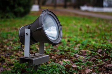architectural illuminator in the park. lantern for artistic illumination of buildings. lantern on the grass.