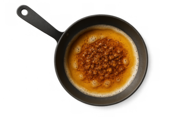 Frying pan full of melted butter browning with breadcrumbs, creating a delicious sauce, top view on transparent background