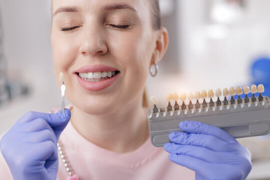 Caucasian female choosing dental veneers at dentist office