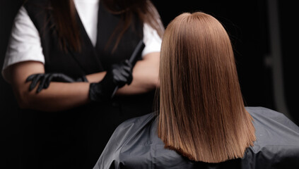 Woman undergoing keratin hair treatment with professional stylist in salon