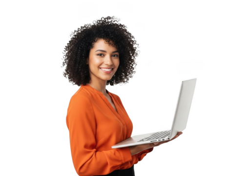 Smiling young woman with curly hair wearing an orange shirt holding a silver laptop isolated on transparent background