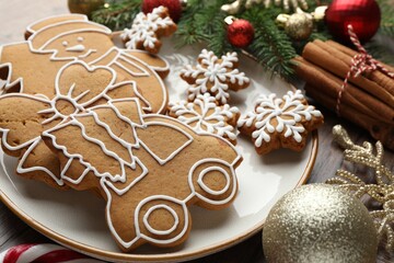 Tasty gingerbread cookies and festive decor on wooden table, closeup