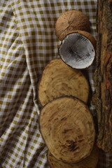 Paisagem rústica com cepos e tronco de madeira, coco seco e técido estampado de piquenique