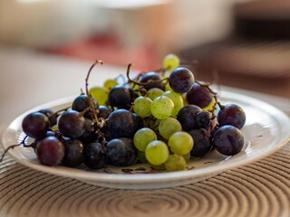 Green and blue grapes on a plate