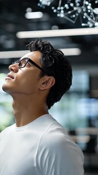 A man looks up with interest in a stylish indoor setting, enjoying a moment of contemplation and inspiration