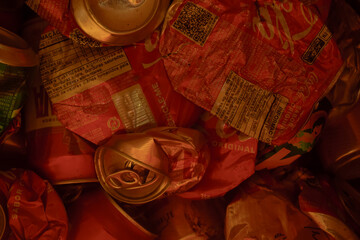 Latinhas de metal amassadas, pilha de material reciclavel com iluminação escura