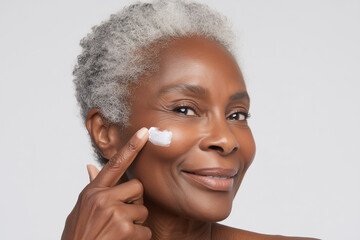 Woman applying cream to her face in a bright and inviting indoor setting