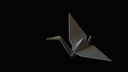 Elegant dark origami crane bird isolated on black background