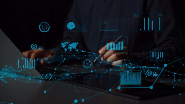 A businessman focuses on data trends using a laptop with digital charts and graphs displayed, highlighting insights for informed financial decision making in a modern office. Xenic