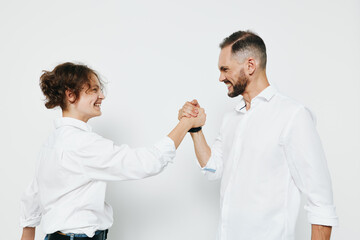 A professional man and colleague share a confident fist bump against an isolated colored background, signaling collaboration, leadership, and positive business energy, with focused expressions.