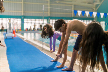Children doing warm up exercises before swimming lesson