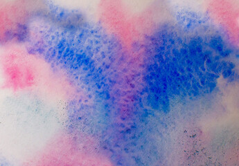 Pink and blue watercolor on white  textured paper close up.