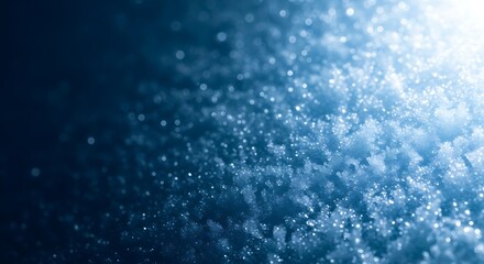A festive winter background of sparkling snow crystals on a dark blue surface creating a magical cold texture