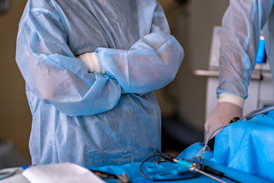 Two surgeons in scrubs standing over a patient in an operating room