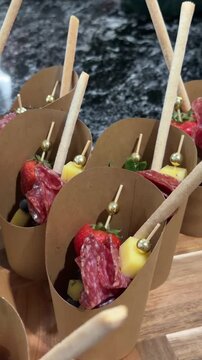 Creative catering: grazing cups with skewered meats, cheese, strawberries, and breadsticks