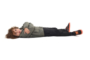   boy dressed in sportswear lying on the ground looking at camera and arms crossed on a white background