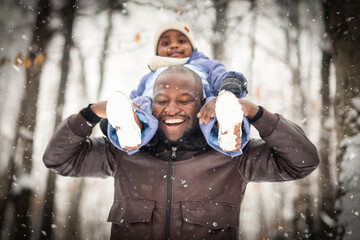 father and child boy in winter forest with parents and kids love relationship having warm clothes...