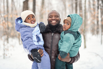father his two child in winter forest with parents and kids love relationship having warm clothes...