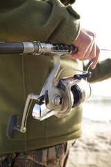 Zatoka, Odessa Oblast, Ukraine. November 15, 2025: Sea fishing. A man in camouflage uniform holds a fishing rod.