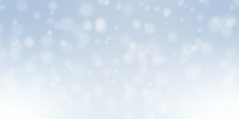 Winter holiday bokeh effect featuring soft, blurred, white luminous circles against a gradient pale blue festive background