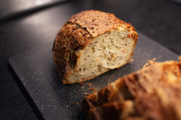 Close-up of sliced gluten free bread on black board.
