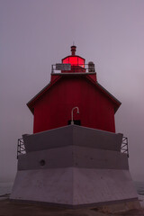 Sunrise on a foggy morning on the Grand Haven south pierhead with the inner light beacon and outer lighthouse.
