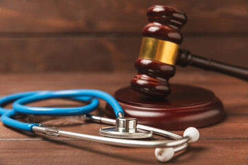 A stethoscope and hammer on a desk. Medical malpractice, personal injury lawyer, and healthcare...