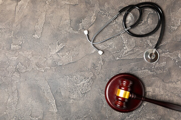 A stethoscope and hammer on a desk. Medical malpractice, personal injury lawyer, and healthcare legal aspects concept.Lawyer.Legal definition of medical negligence. Law concept.Healthcare and Medicine