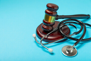 A stethoscope and hammer on a desk. Medical malpractice, personal injury lawyer, and healthcare...