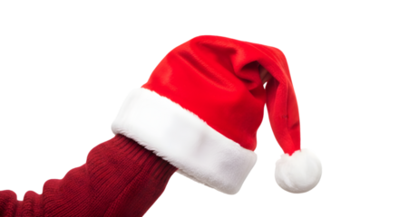 Human hand holding a soft red Santa Claus hat with white fluffy trim, isolated on white background, cozy festive clothing.