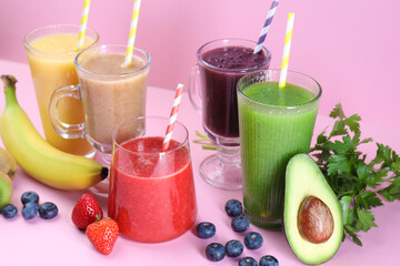 Different tasty smoothies in glasses and ingredients on pink background, closeup