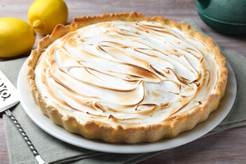 Delicious lemon meringue pie, fresh fruits and cake server on wooden table, closeup