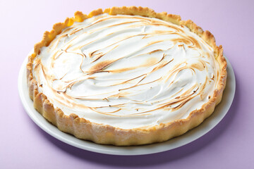 Tasty lemon meringue tart on lilac background, closeup