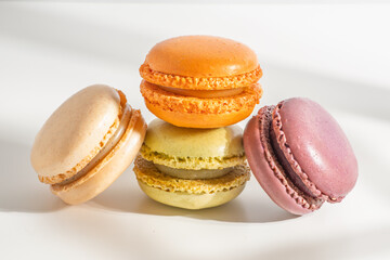 Four colorful macarons are stacked and leaning against each other