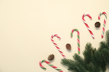 Flat lay composition with candy canes on beige background, space for text. Christmas treat