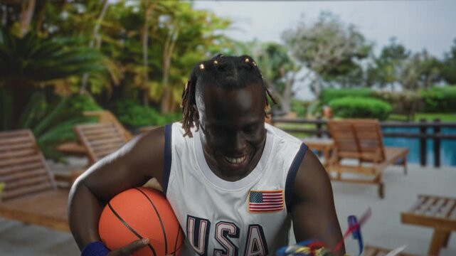 Man holding basketball and gold trophy, hand gripping ball, shouting in building poolside resort; victory celebration pride.