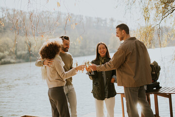 Friends celebrating friendship at the lakeside during a sunny afternoon gathering in nature