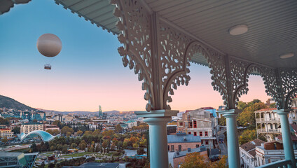 View of Tbilisi Rike Park, buildings, and mountains from a decorated balcony © EdNurg