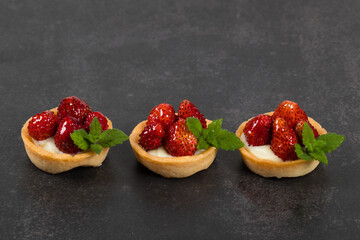 Mini dessert. Mini Round Strawberry tartlets. Dark background. Close up	