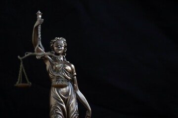 Naklejka premium Lady Justice female statue on black backdrop. Law and justice concept