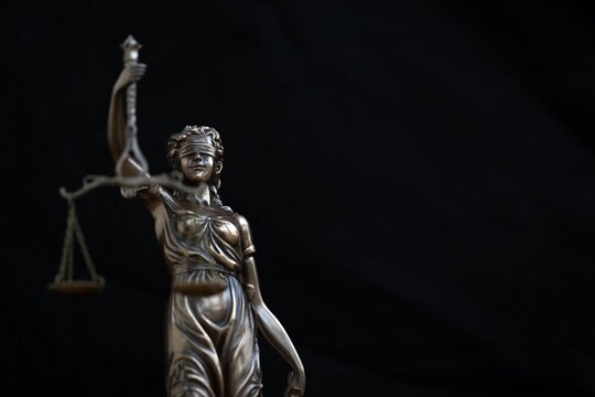 Lady Justice female statue on black backdrop. Law and justice concept - Powered by Adobe