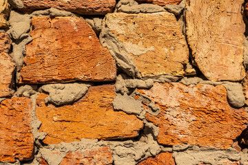 Beautiful rustic wall made of orange and red bricks with gray mortar showcasing texture and craftsmanship