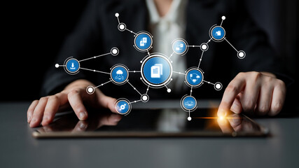 A business professional interacts with a tablet displaying various connected digital icons representing data management and technology innovations in a modern workspace. Tessel