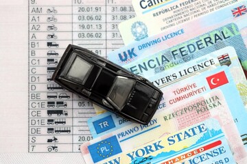 Toy car on driving licenses from different countries and American states. Concept of obtaining...