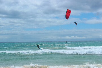 Kitesurfers Riding Waves at Sotavento Beach, Fuerteventura on a Sunny Day